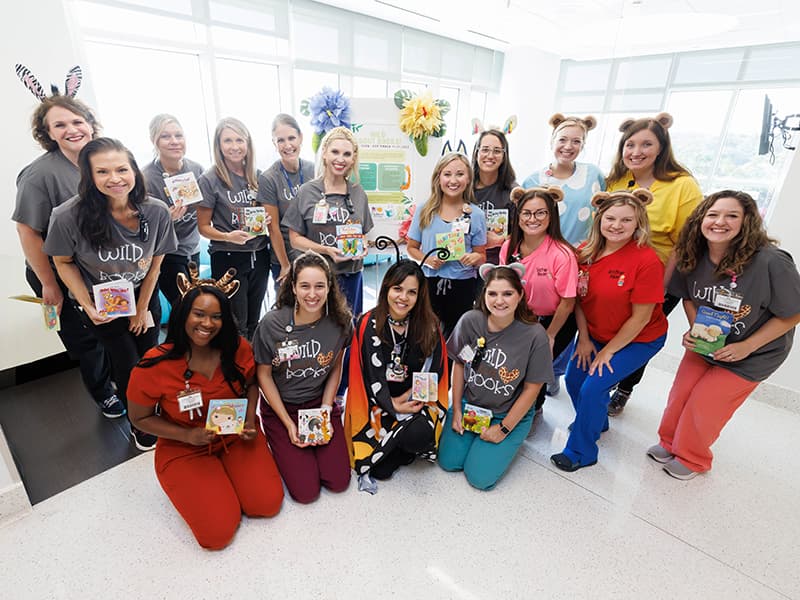 NICU care team members dressed as wild animals and storybook characters to promote reading.